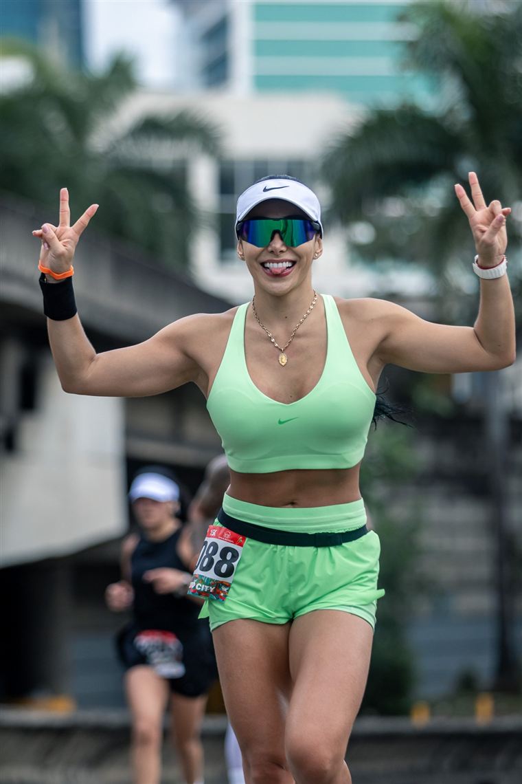 Corredora celebrando con las manos en V durante una carrera