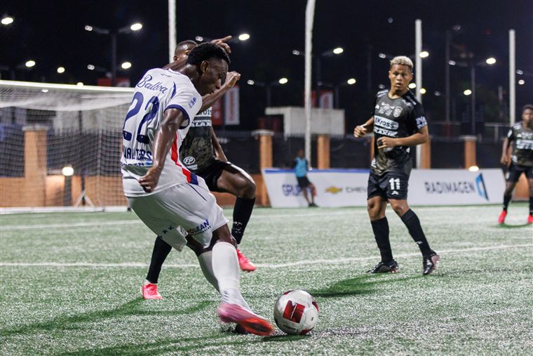 Futbolista conduciendo el balón en un partido nocturno