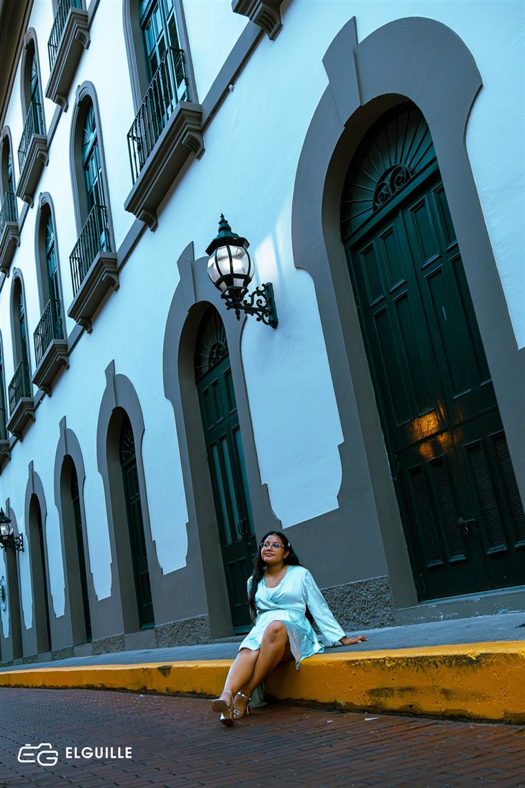 Retrato frente a una fachada colonial azul